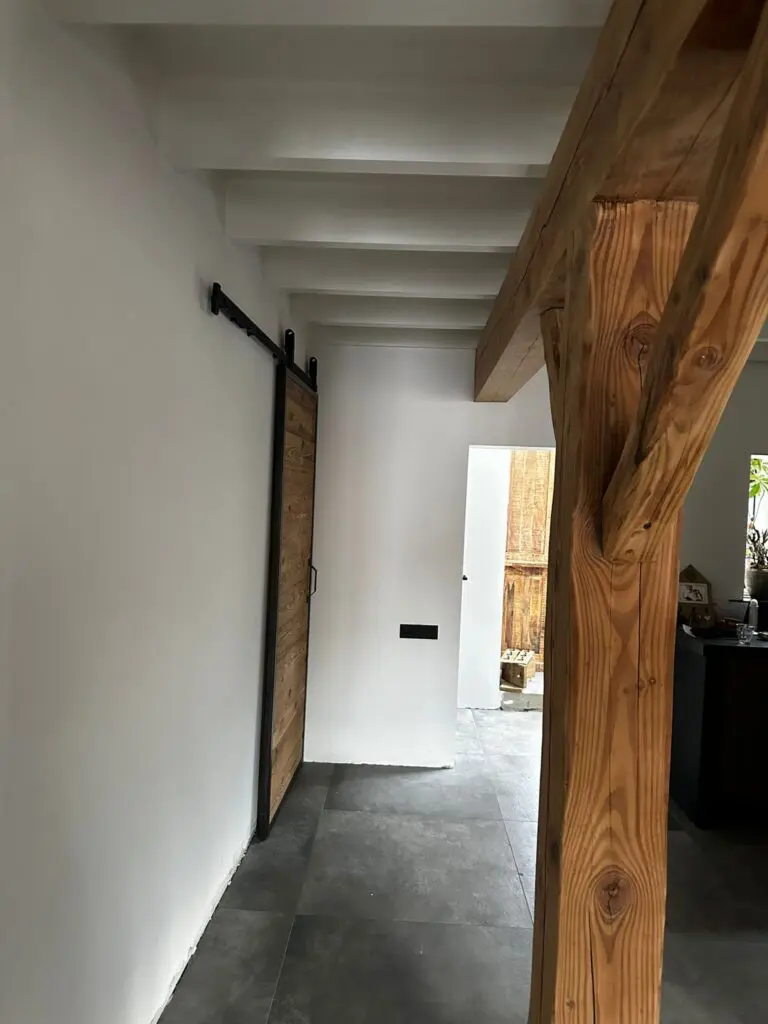 Gestucte muren en keuken met houten pilaar